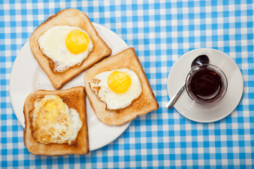 Wall Mural - Breakfast. Сup of tea, toast and eggs on a blue table