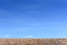 Stone Wall And Blue Sky With Clouds, Background Free Space For Text
