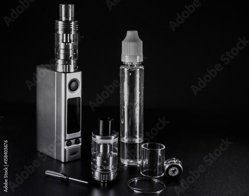 Zdjęcie XXL vape e ciecz i vaping urządzenia do elektronicznego papierosa na ciemnym tle