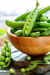 Wall Mural - Pods of sweet peas in a wooden bowl.