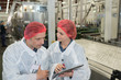 Man and woman in factory looking at tablet screen