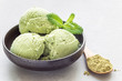 Matcha green tea ice cream balls in black bowl, horizontal, copy space