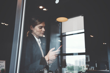 Portrait of business lady using mobile phone in big open space office