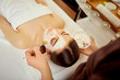 © Studio Romantic - Cosmetologist puts a mask from cream on girl's face in the spa salon.