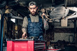 © Fxquadro - Mechanic holds angle grinder on a shoulder.