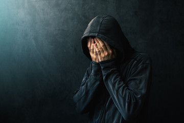 Wall Mural - Desperate man in hooded jacket is crying