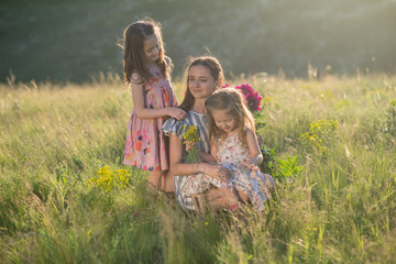 family portrait of mother with two daughters during nature stroll