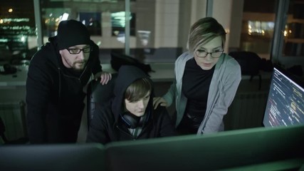 Wall Mural - young male computer programmers and their female colleague working on computer late in the office