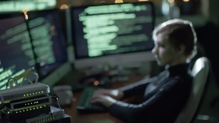 Wall Mural - young woman with short haircut working with program code on computer workstation in dark office