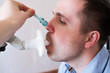 © RealPeopleStudio - Young man testing breathing function by spirometry. Doctor closing his nose