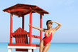 Sexy woman in red swimsuit beside lifeguard tower