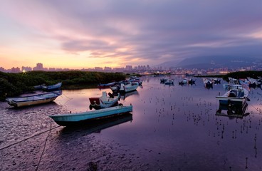 Wall Mural - Scenic view of fishing boats & wetlands under dramatic sky at Bali of New Taipei City, Taiwan ~ Sunrise scenery of Tamsui River with boats stranded by the riverbank at a low tide in morning twilight