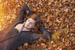Beautiful Woman lying on Autumn leaves and dreaming