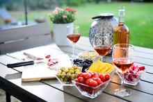 Holiday Summer Brunch Party Table Outdoor In A House Backyard With Appetizer, Glass Of Rosé Wine, Fresh Drink And Organic Vegetables