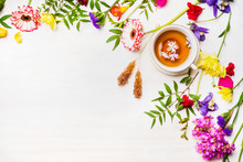 Herbal Tea Laid Out Beside Fresh Colorful Spring Flowers And Sugar Sticks, Border, Place For Text