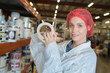 Woman in protective clothing in hardware store holding roll of tape