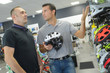 © auremar - seller helps customer to choose helmet for cycling in shop