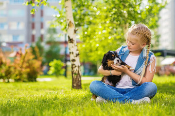 Poster - Little girl with a berner sennenhund puppy, outdoor, summer