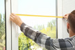 © Africa Studio - Young man installing window shades at home