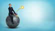 © gearstd - A small businessman riding a big round bomb with a lit fuse on blue background.