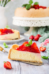 Wall Mural - Piece of delicious homemade strawberry cheesecake and flowers on gray stone background. Selective focus.