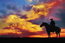 Silhouette Of Cowboy On Horse Against Cloudy Evening Sky
