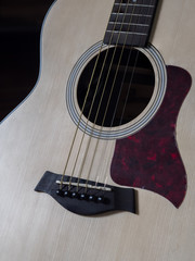 Close up shot of acoustic guitar. Strings, sound hole , bridge, pickguard