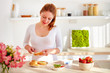© Olesia Bilkei - happy young woman preparing tasty snacks at the kitchen table in the morning light
