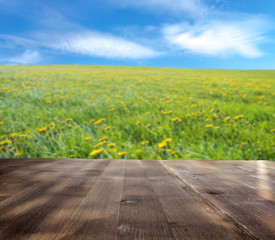 Wall Mural - wood table and blurry meadow in background. Empty table for display product.