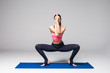 © F8  \ Suport Ukraine - Young attractive woman practicing yoga, standing in different yoga exercise, wearing sportswear isolated on grey background. Series of Yoga position concept