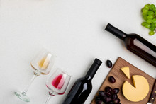 Two Wine Glasses With Red And White Wine,bottles Of Red Wine And White Wine, Cheese On White Background. Horizontal View From The Top.