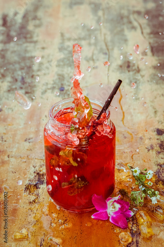 Fotografía Close up of glass with refreshing strawberry cocktail with lime, mint with splas