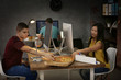 © Africa Studio - Young programmers eating pizza while working in office