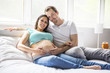 © Louis-Paul Photo - Young parents in bed expecting a little baby, Romantic moments for pregnant couple