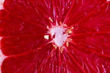 Red juicy cut of grapefriut, macro background