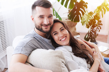 Wall Mural - Gorgeous girl and guy hugging and relaxing on sofa