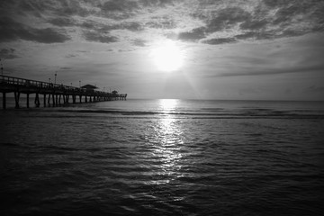 sun over ocean with cloudy sky in black and white style