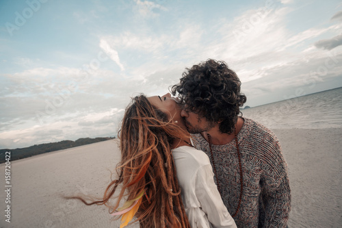 Fotografía beautiful young couple kissing on beach at sunset
