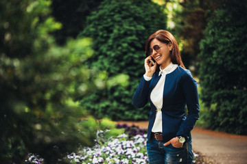 Woman outdoors in park talking on mobile phone