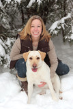 Fototapeta Las - blonde smiling woman in snow with dog