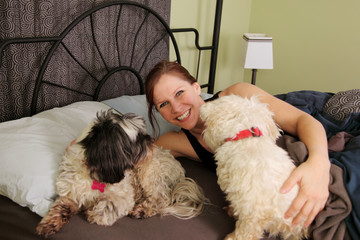  woman in bed with pet dogs 