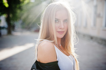 Stylish blonde woman wear at jeans, sunglasses and jacket posed at street on sunshine. Fashion urban model portrait.