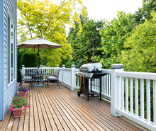 Home Deck And Patio With Outdoor Furniture And BBQ Cooker With Bottled Beer