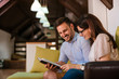 © bnenin - Romantic couple laughing together and reading a book.