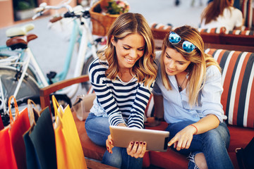 Two young women buying over the Internet via a digital tablet