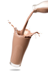 Pouring chocolate milk from bottle into glass with splashing., Isolated on white background.