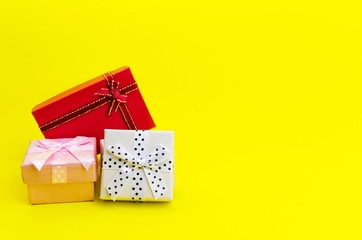 Wall Mural - mini colorful gifts box on yellow background, holiday sale concept, selective focus, copy space