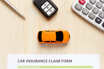 Wall Mural - Top view of car insurance with car key, car toy and calculator on wooden desk.