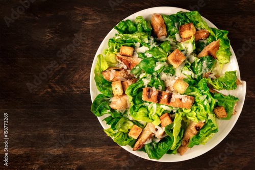 Fotografía Chicken Caesar salad on rustic background with copyspace