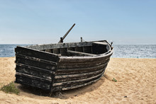 An Old Abandoned Boat On The Seashore Is Awaiting Its Fate
